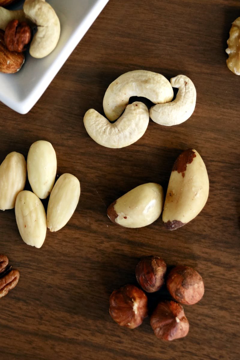 pexels photo 1295572 1295572 Close-up of various nuts on a wooden table, showcasing healthy snacking options.