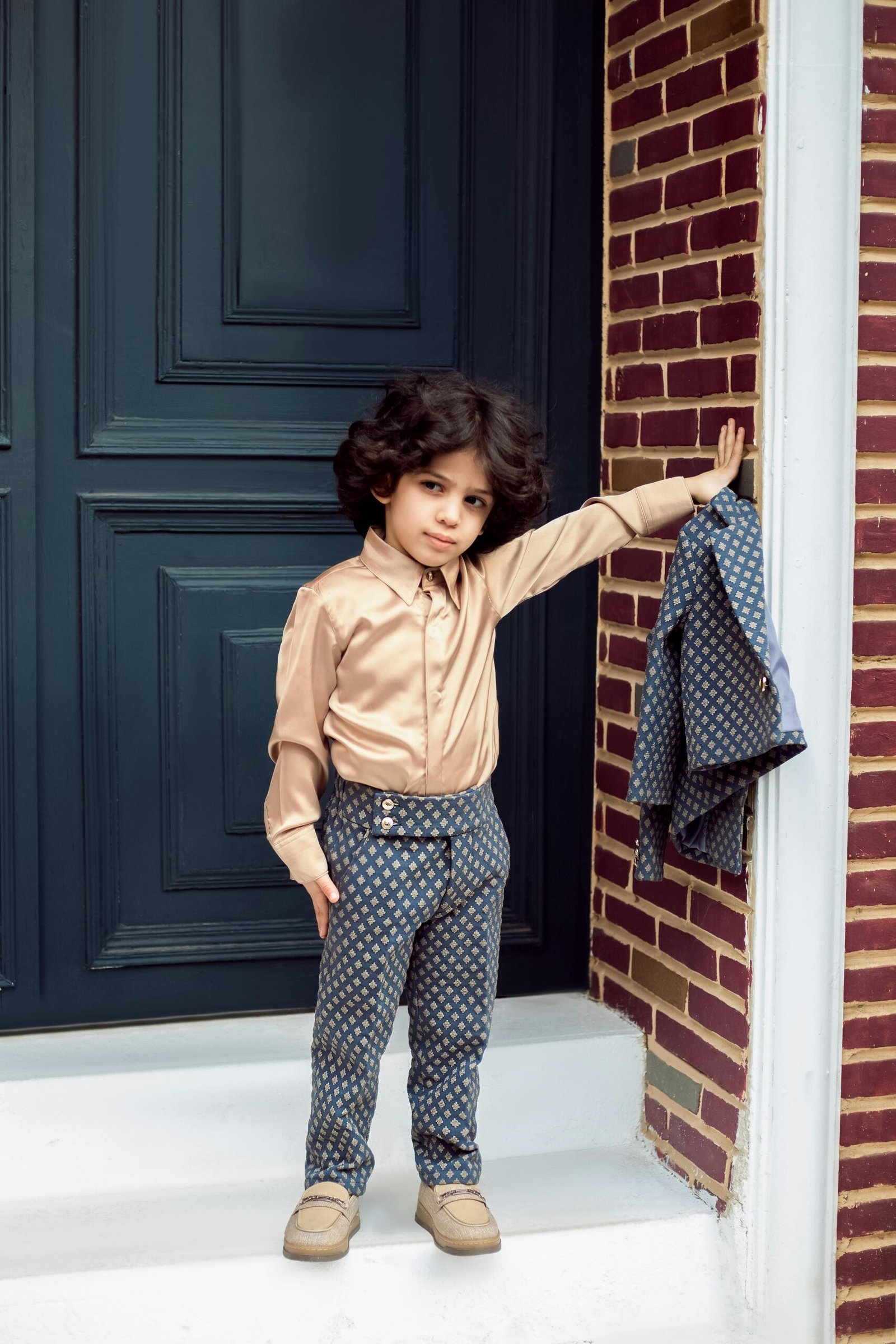 pexels photo 20215089 20215089 A young child dressed impeccably in a fashionable outfit poses confidently by a doorway in an urban setting.